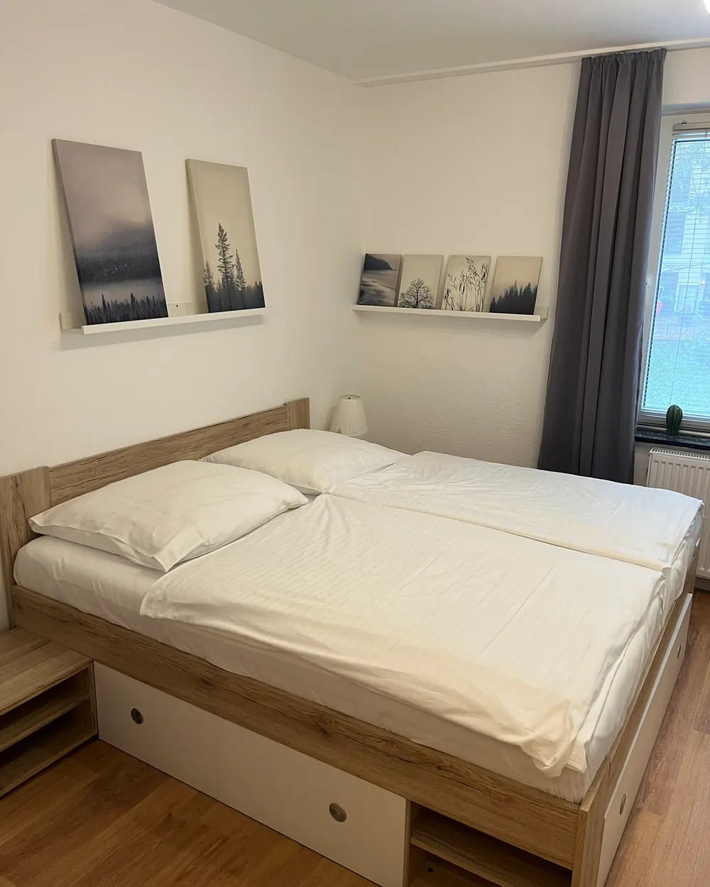 Doppelbett mit Bettkasten, daneben das Fenster