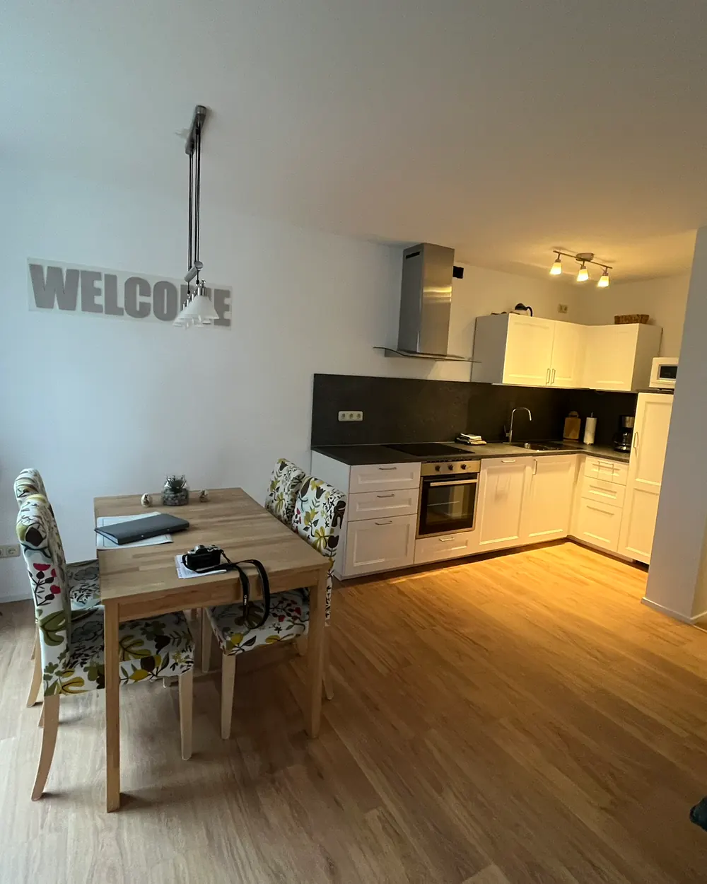 Offener Ess- und Küchenbereich mit „Welcome“-Schriftzug
