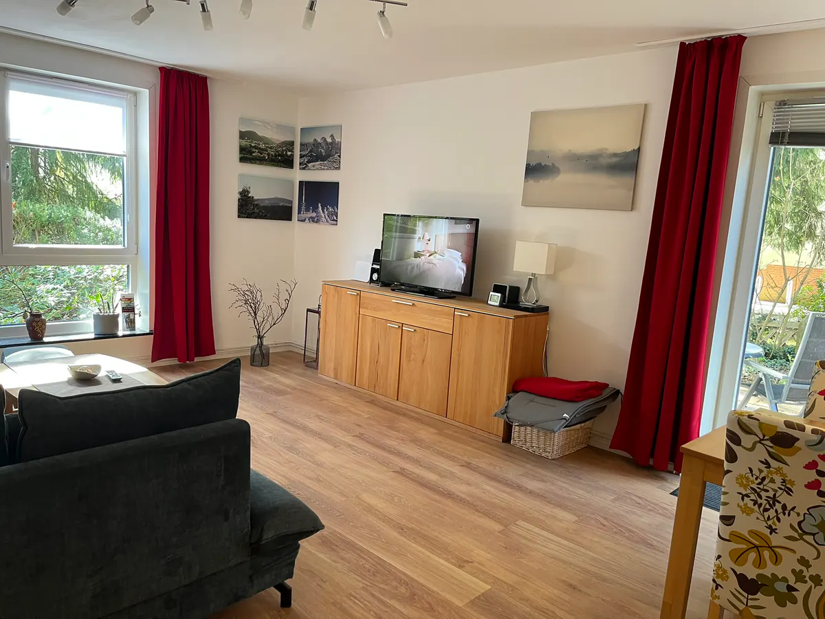 Wohnzimmer mit Sofa, Fernseher und Sideboard