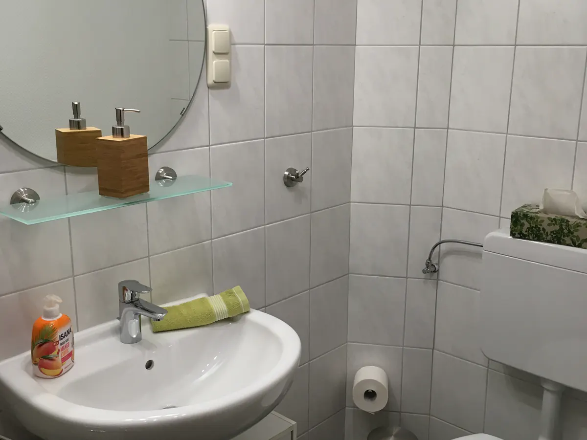 Waschbecken mit Rundspiegel im Bad