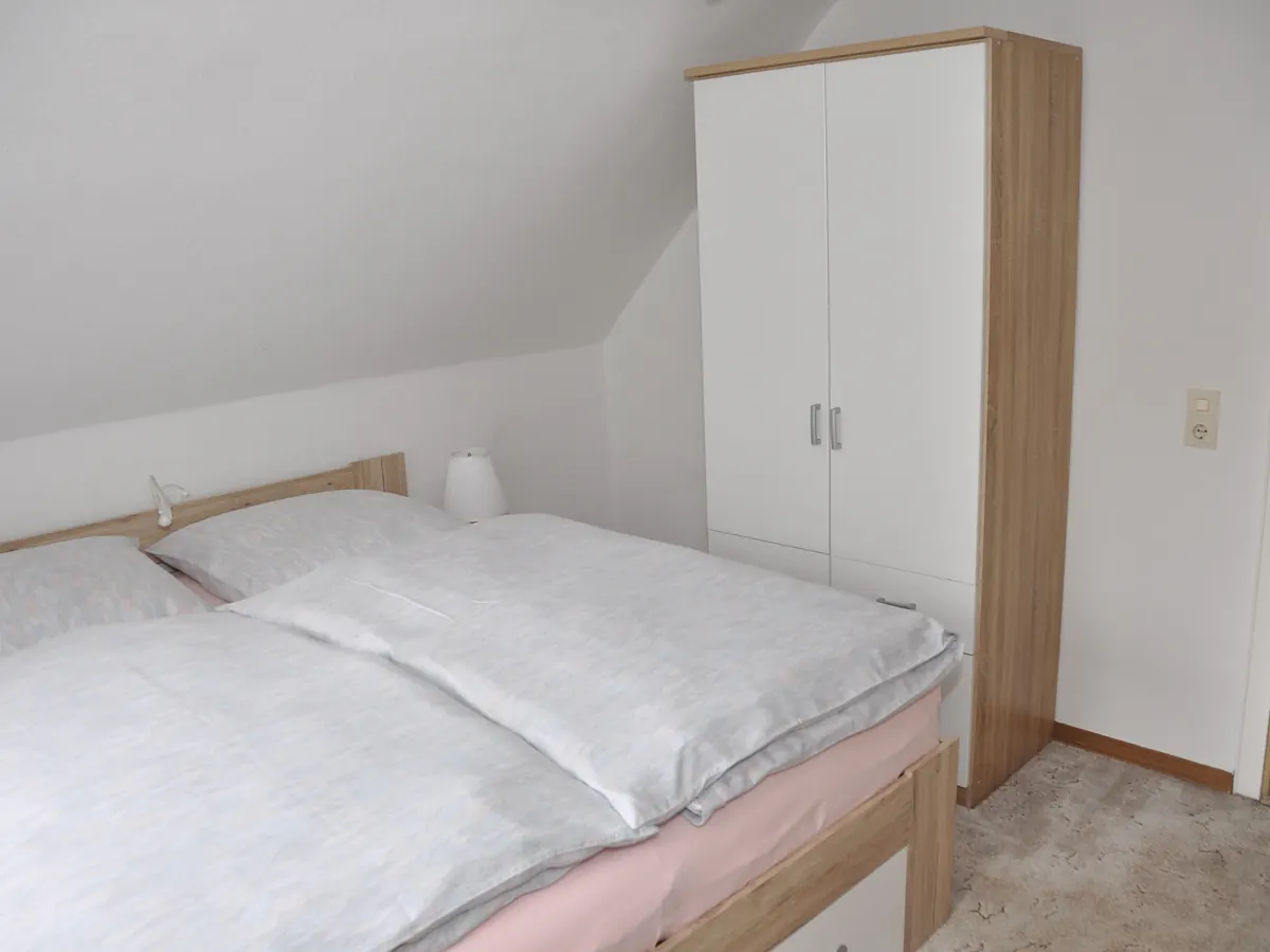 Schlafzimmer unter der Dachschräge mit Kleiderschrank