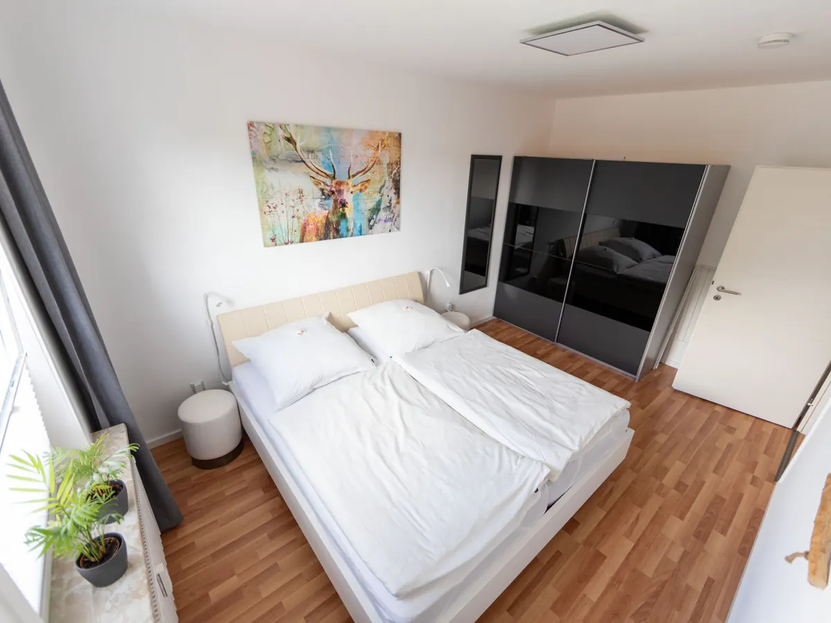 Schlafzimmer mit Wandbild und Kleiderschrank